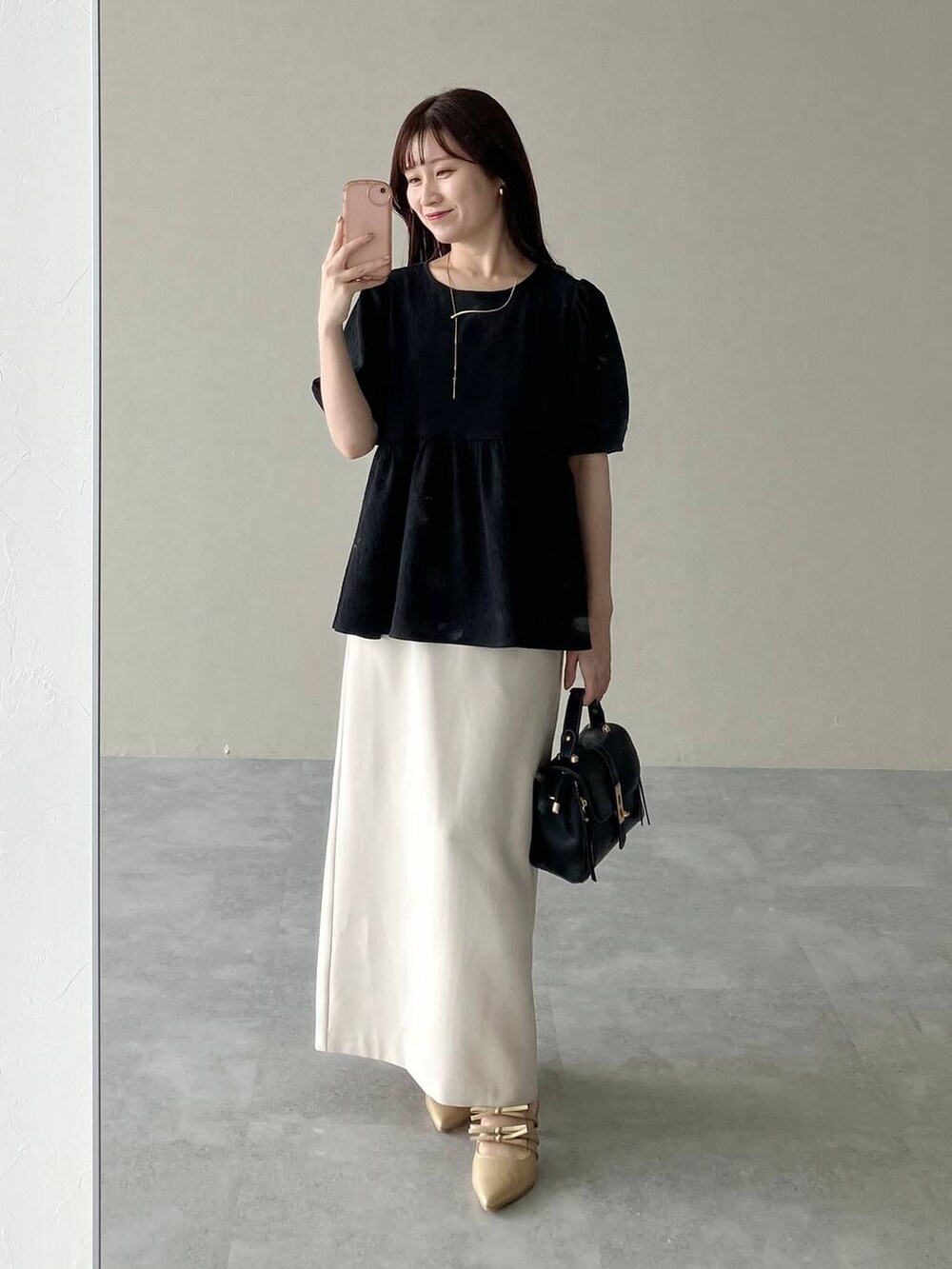 ゴールド系のパンプス、ブラック系のショルダーバッグ、ブラック系のシャツ/ブラウスを着用したレディースの夏コーディネートの4枚目の写真