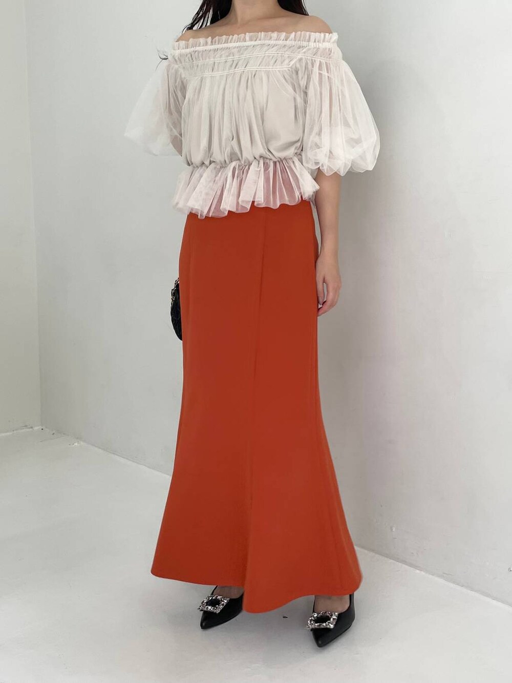 ブラック系のパンプス、ホワイト系のシャツ/ブラウス、ブラック系のショルダーバッグを着用したレディースの夏コーディネートの5枚目の写真