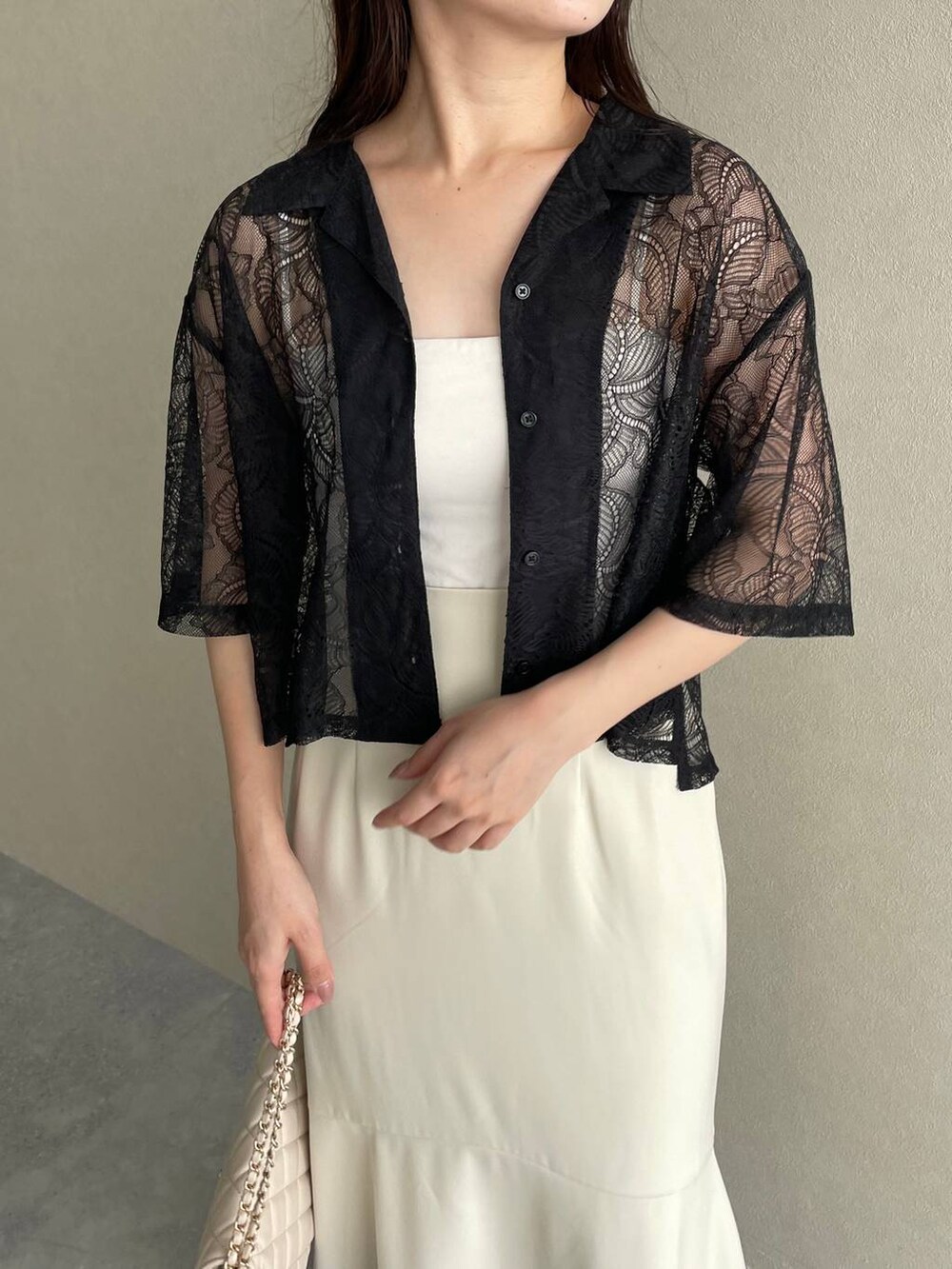 ホワイト系のショルダーバッグ、ホワイト系のサンダル、ブラック系のシャツ/ブラウスを着用したレディースの夏コーディネートの3枚目の写真