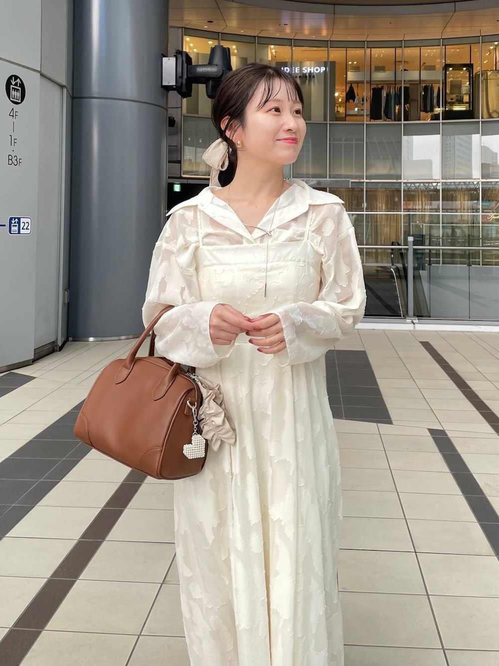 ブラック系のワンピース、ブラウン系のショルダーバッグ、ベージュ系のキーホルダーを着用したレディースの秋コーディネートの3枚目の写真