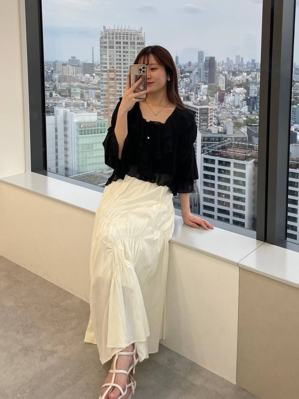 ブラック系のシャツ/ブラウス、ブラック系のハンドバッグ、ホワイト系のサンダルを着用したレディースの春コーディネートの5枚目の写真