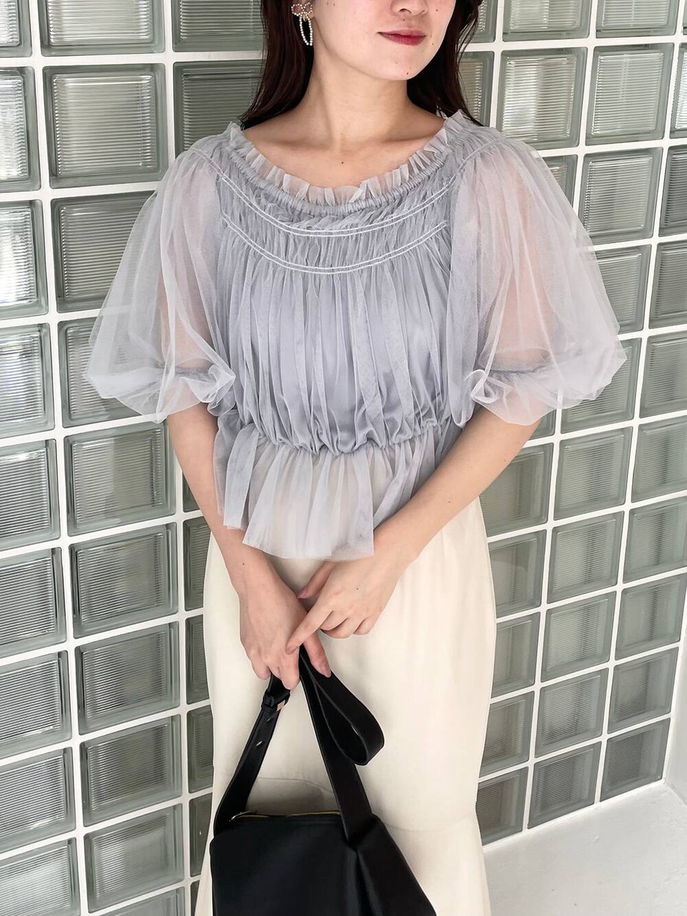 ブラック系のショルダーバッグ、ブラック系のサンダル、ブルー系のシャツ/ブラウスを着用したレディースの夏コーディネートの3枚目の写真