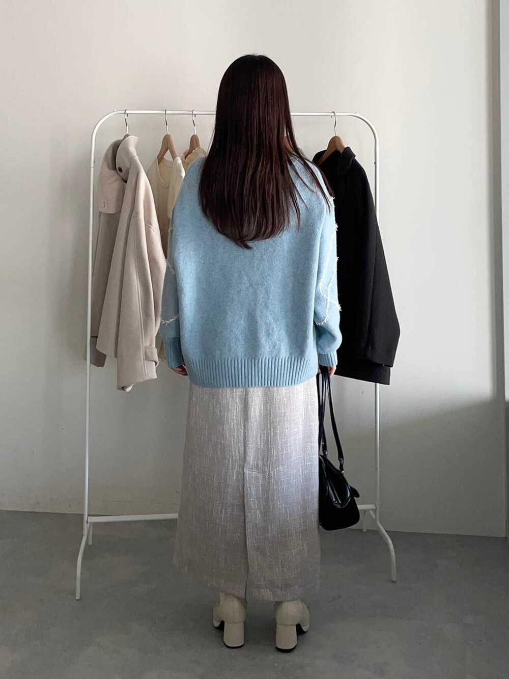 ブラック系のその他アウター、ホワイト系のブーツ、ブラック系のハンドバッグを着用したレディースの冬コーディネートの4枚目の写真