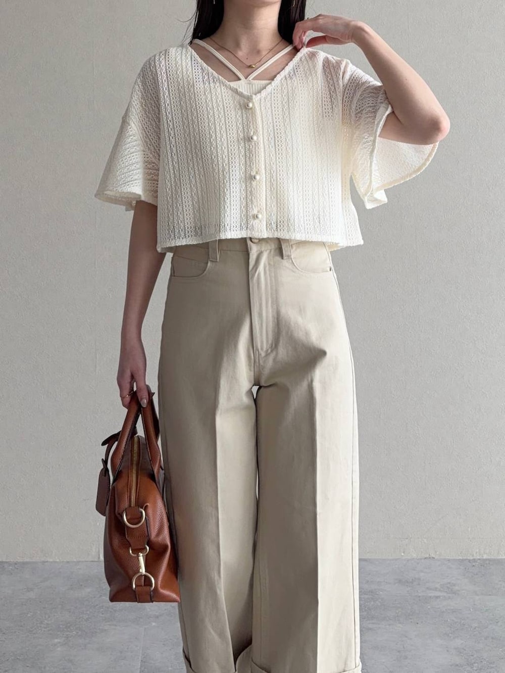 ホワイト系のカーディガン/ボレロ、ブラウン系のボストンバッグ、ブラウン系のサンダルを着用したレディースの春コーディネートの3枚目の写真