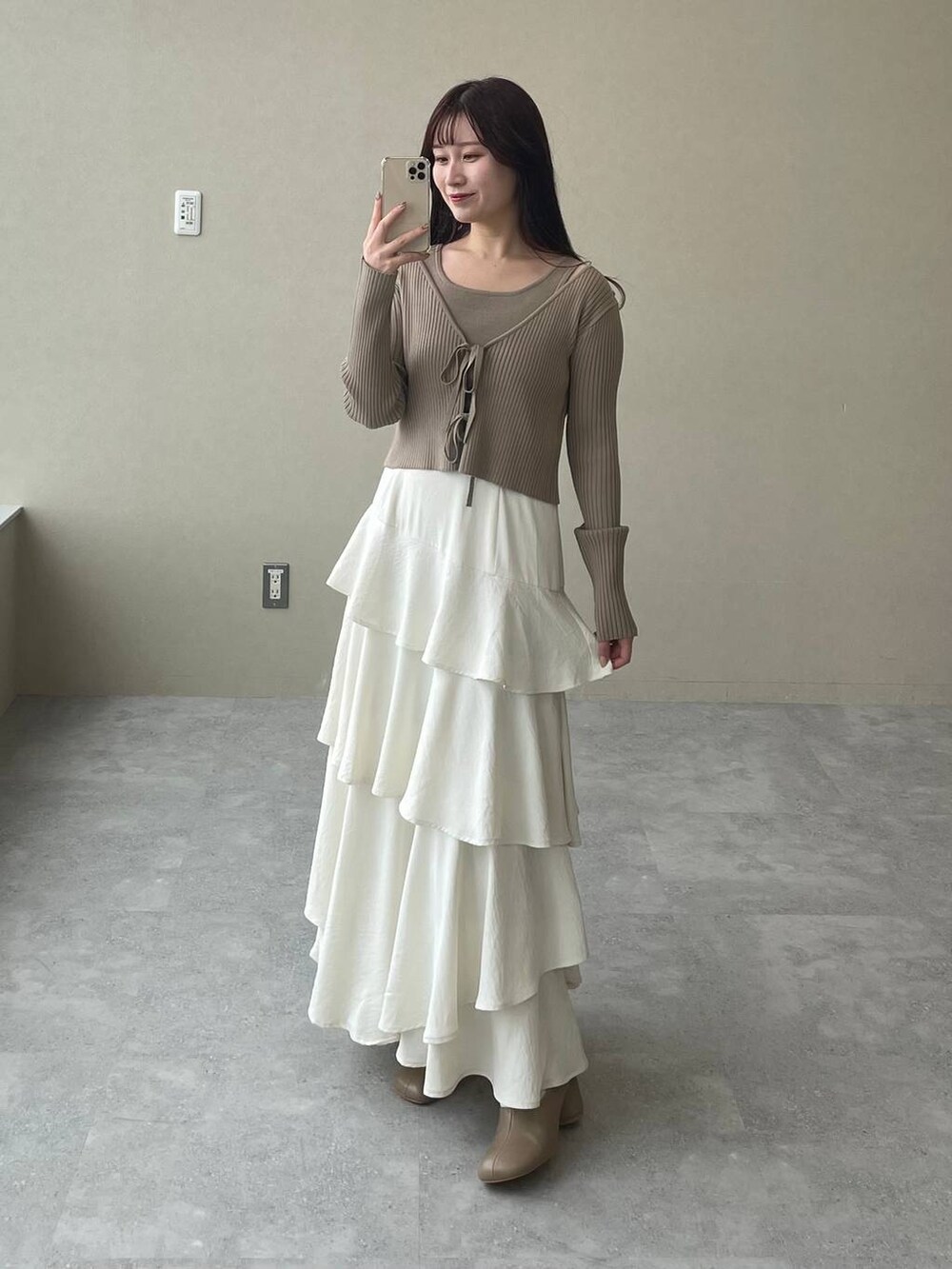 ホワイト系のスカート、ベージュ系のショルダーバッグ、ブラウン系のパンプスを着用したレディースの冬コーディネートの4枚目の写真