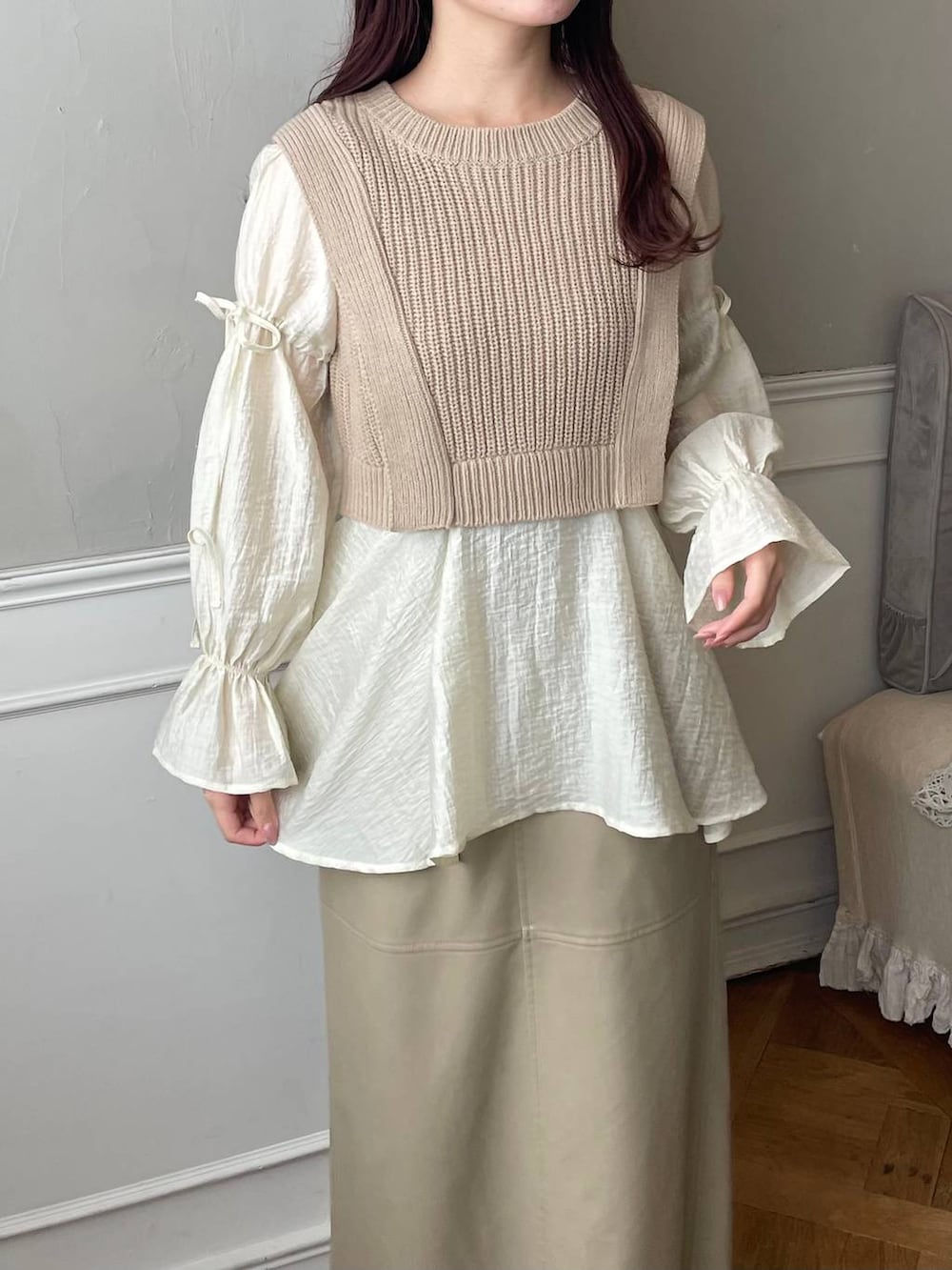 ブラウン系のブーツ、ホワイト系のショルダーバッグ、ベージュ系のスカートを着用したレディースの冬コーディネートの3枚目の写真