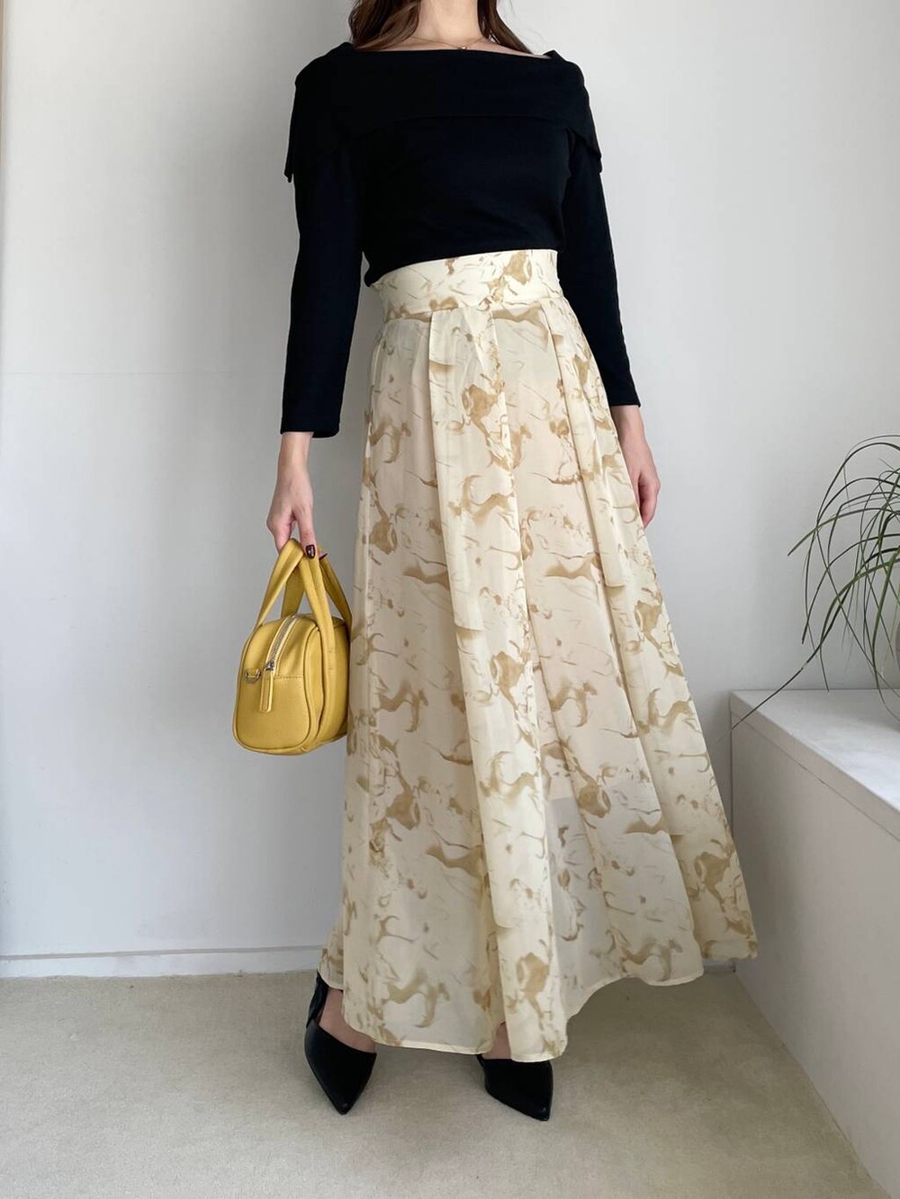 イエロー系のスカート、イエロー系のボストンバッグ、ブラック系のTシャツ/カットソーを着用したレディースの夏コーディネートの4枚目の写真