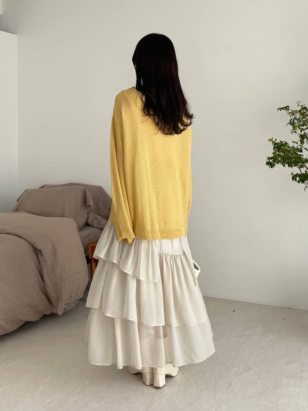 ホワイト系のスカート、イエロー系のTシャツ/カットソー、ホワイト系のブーツを着用したレディースの春コーディネートの2枚目の写真
