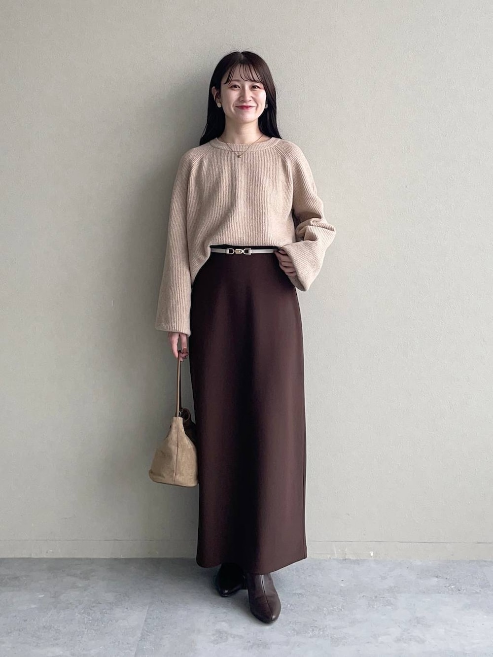 ベージュ系のニット/セーター、ベージュ系のマウンテンパーカー、ブラウン系のスカートを着用したレディースの秋コーディネートの3枚目の写真