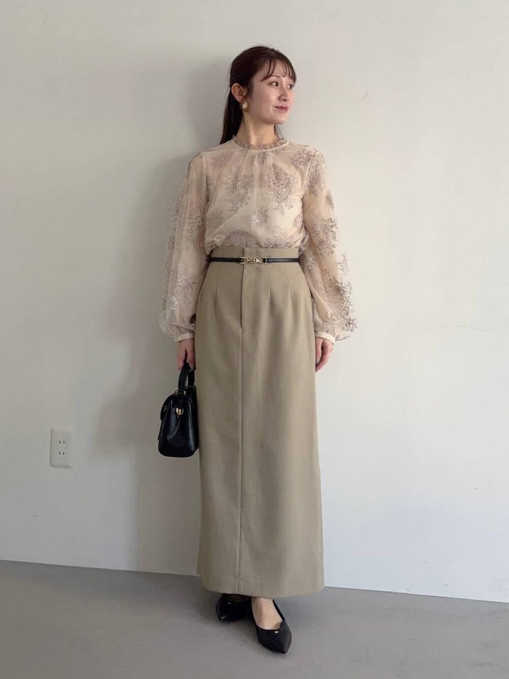 ブラック系のショルダーバッグ、ベージュ系のテーラードジャケット、ベージュ系のスカートを着用したレディースの冬コーディネートの3枚目の写真