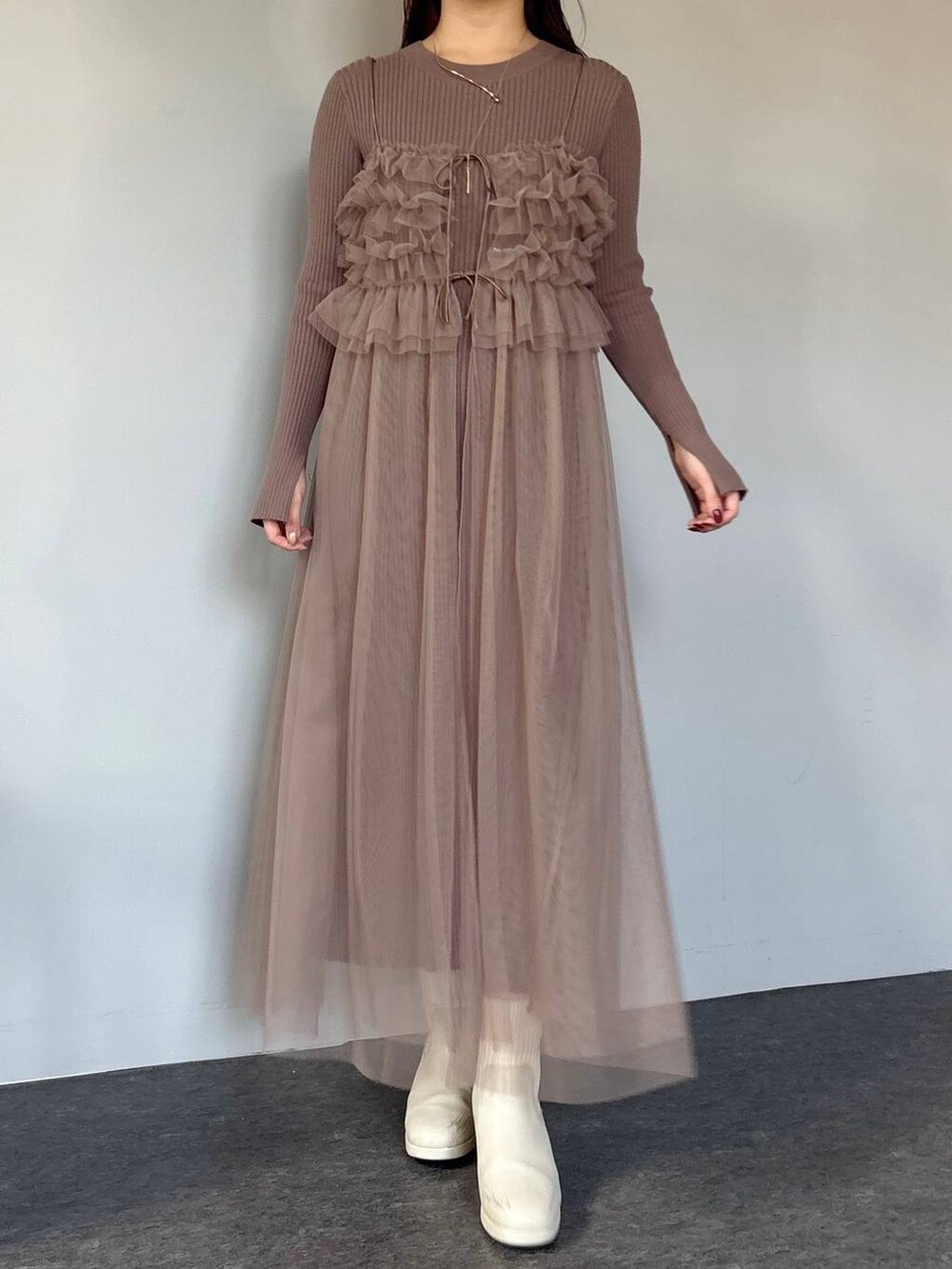 ホワイト系のブーツ、ブラウン系のワンピース、ホワイト系のハンドバッグを着用したレディースの冬コーディネートの4枚目の写真