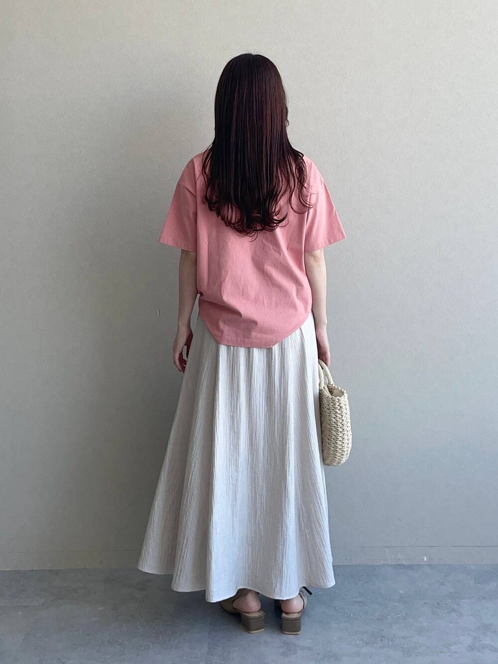 ブラウン系のサンダル、ピンク系のTシャツ/カットソー、ベージュ系のスカートを着用したレディースの春コーディネートの2枚目の写真