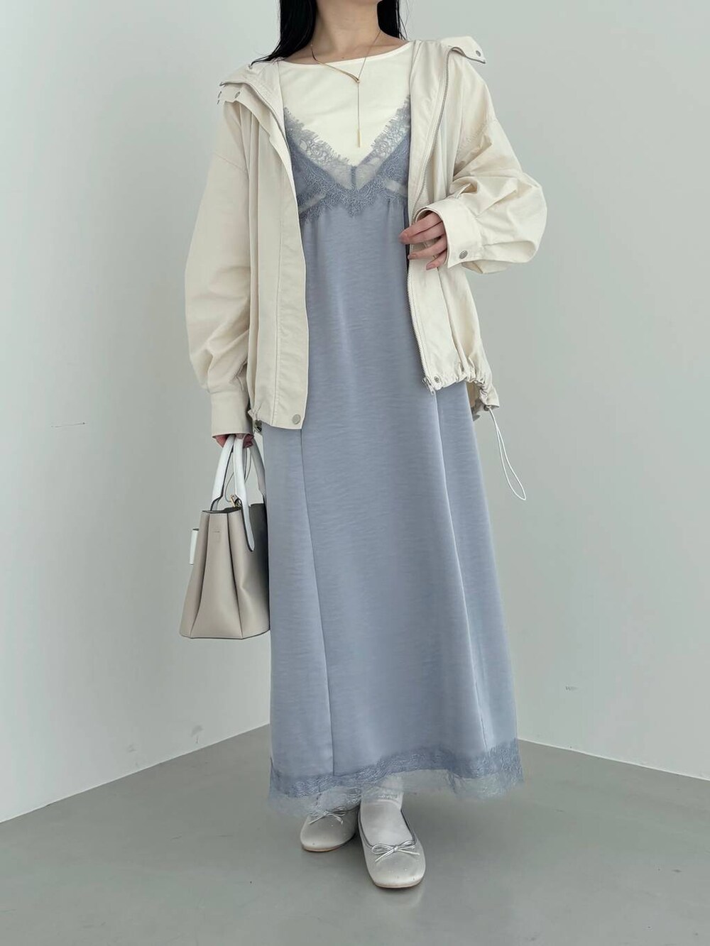 ベージュ系のショルダーバッグ、ホワイト系のマウンテンパーカー、シルバー系のバレエシューズを着用したレディースの春コーディネートの4枚目の写真