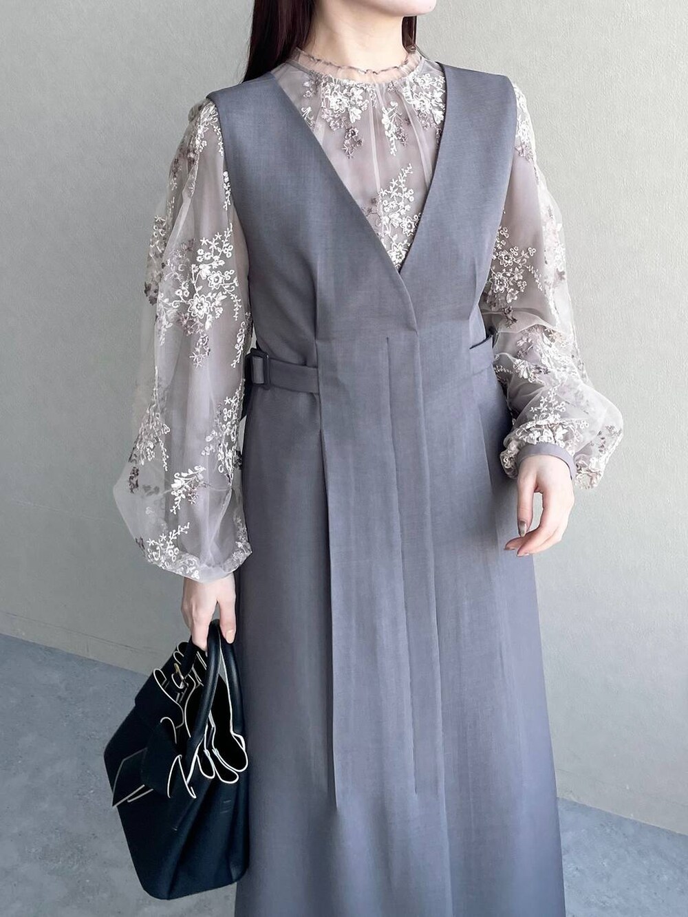 ブラウン系のシャツ/ブラウス、ブラック系のショルダーバッグ、グレー系のジャンパースカートを着用したレディースの冬コーディネートの3枚目の写真