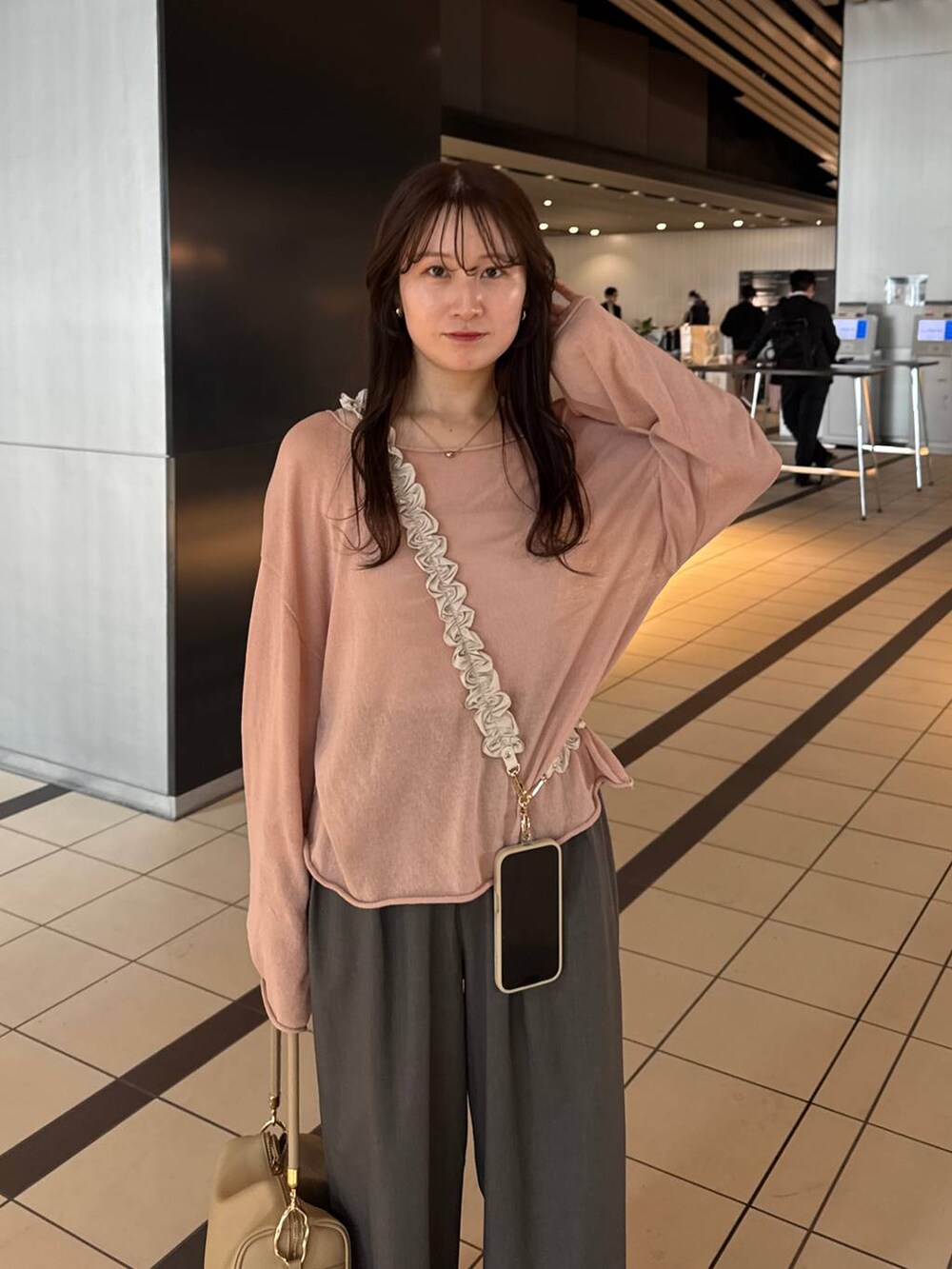 ピンク系のニット/セーター、ゴールド系のボストンバッグを着用したレディースの春コーディネートの2枚目の写真
