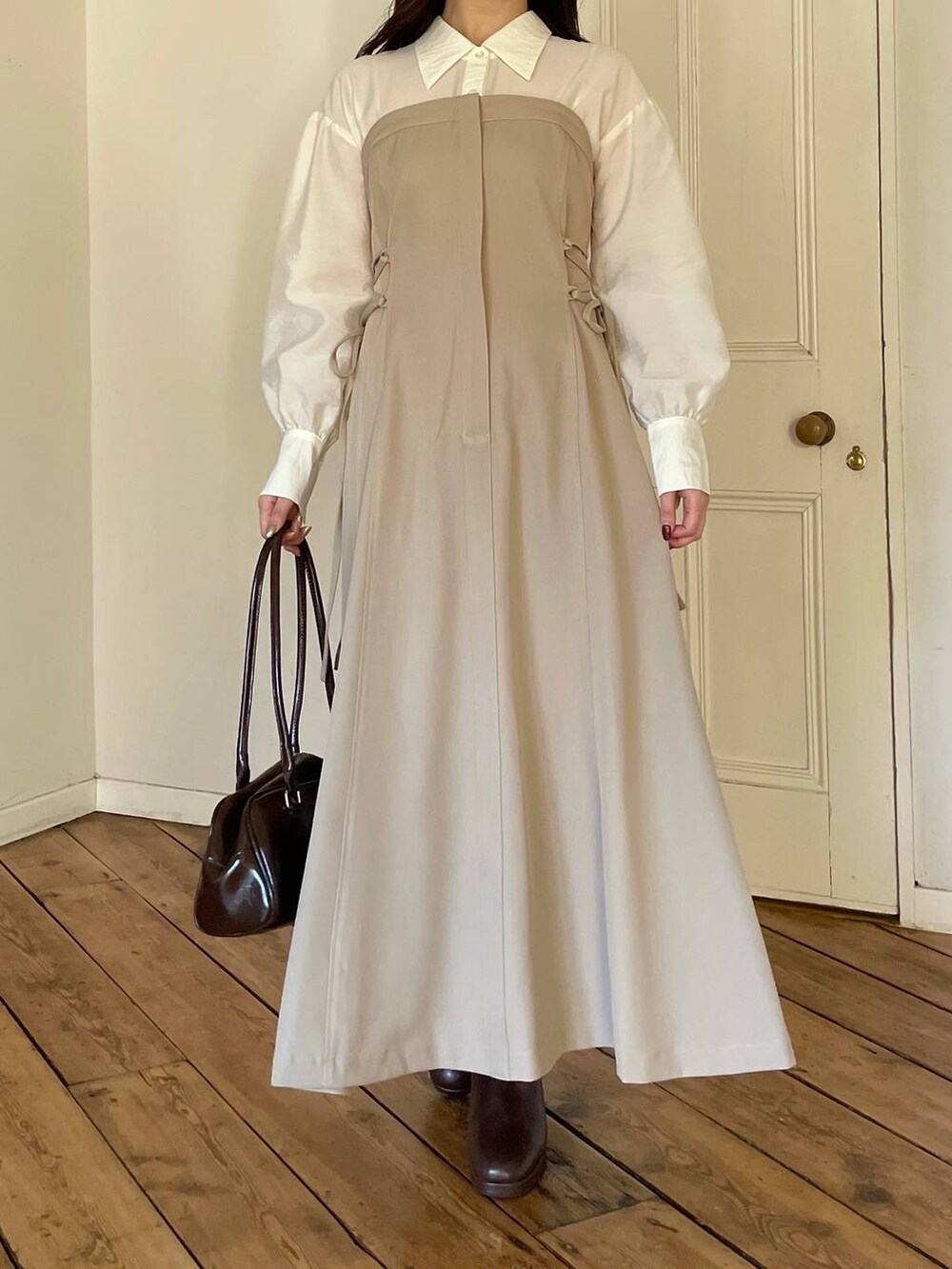 ブラウン系のブーツ、ブラウン系のハンドバッグ、ベージュ系のワンピースを着用したレディースの冬コーディネートの4枚目の写真