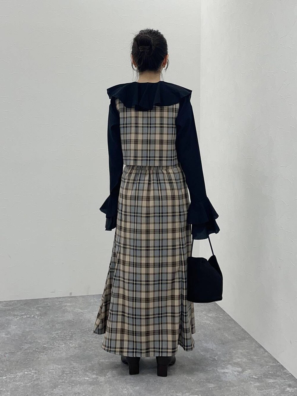 ブラック系のシャツ/ブラウス、ブラック系のブーツ、ブラック系のハンドバッグを着用したレディースの秋コーディネートの2枚目の写真