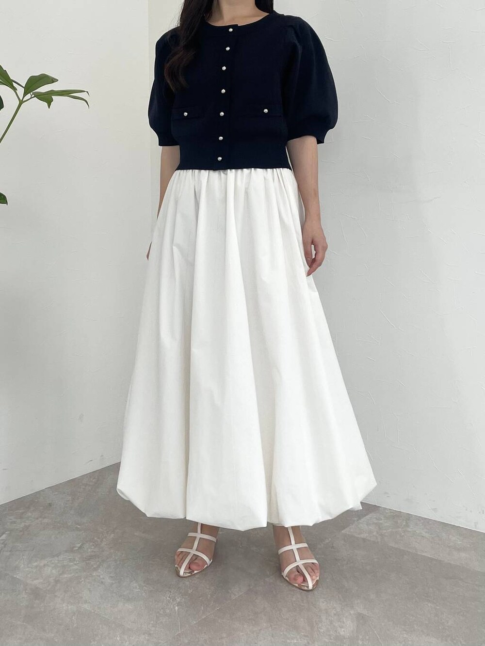 ホワイト系のスカート、ブラック系のショルダーバッグ、ホワイト系のサンダルを着用したレディースの夏コーディネートの4枚目の写真