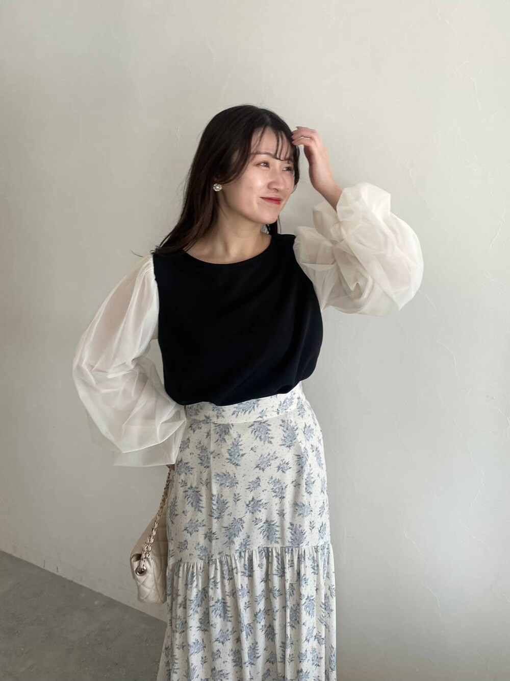 シルバー系のバレエシューズ、ブルー系のスカート、ホワイト系のショルダーバッグを着用したレディースの冬コーディネートの4枚目の写真