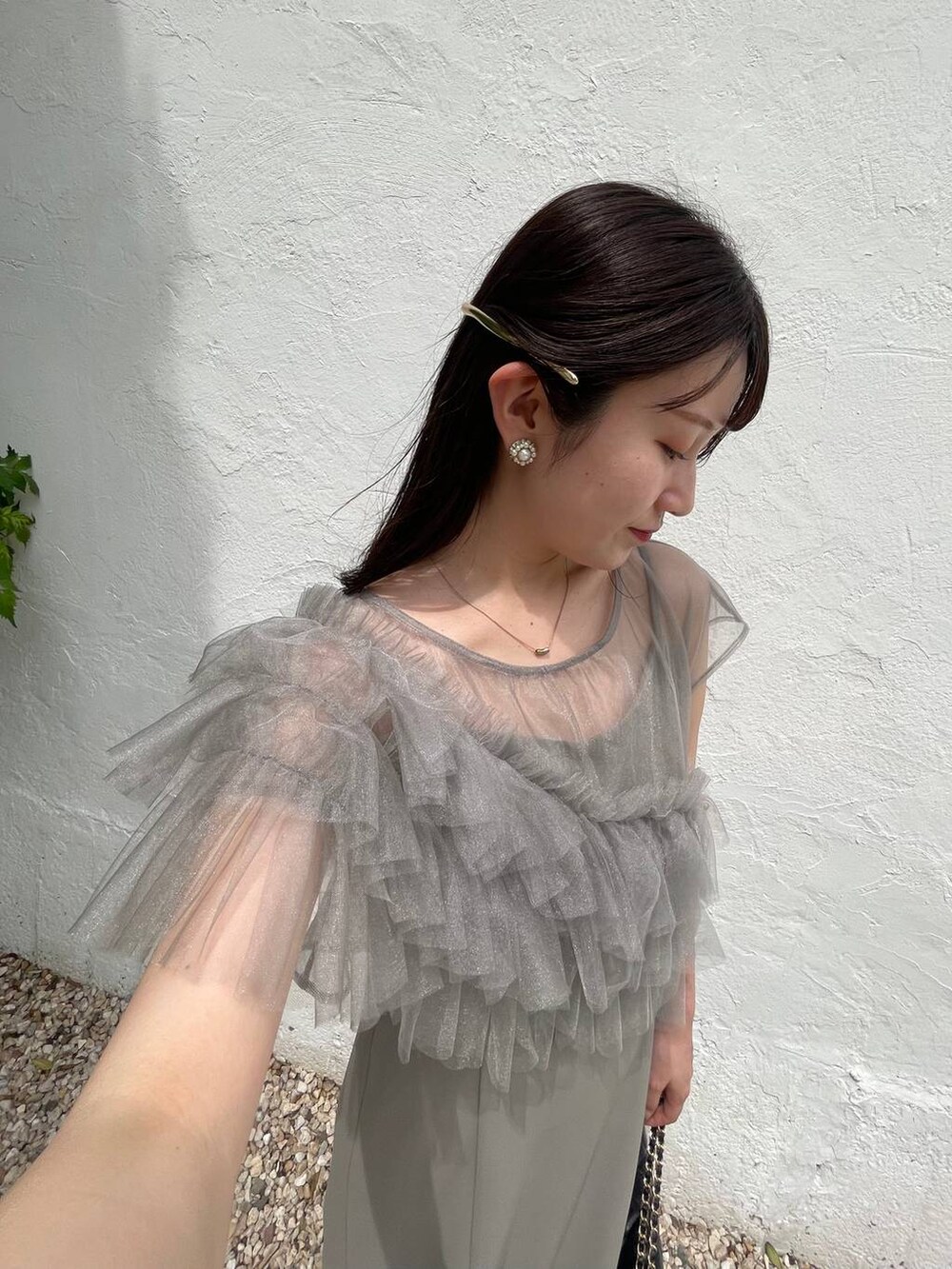 ブラック系のパンプス、グリーン系のドレス、ブラック系のショルダーバッグを着用したレディースの夏コーディネートの3枚目の写真