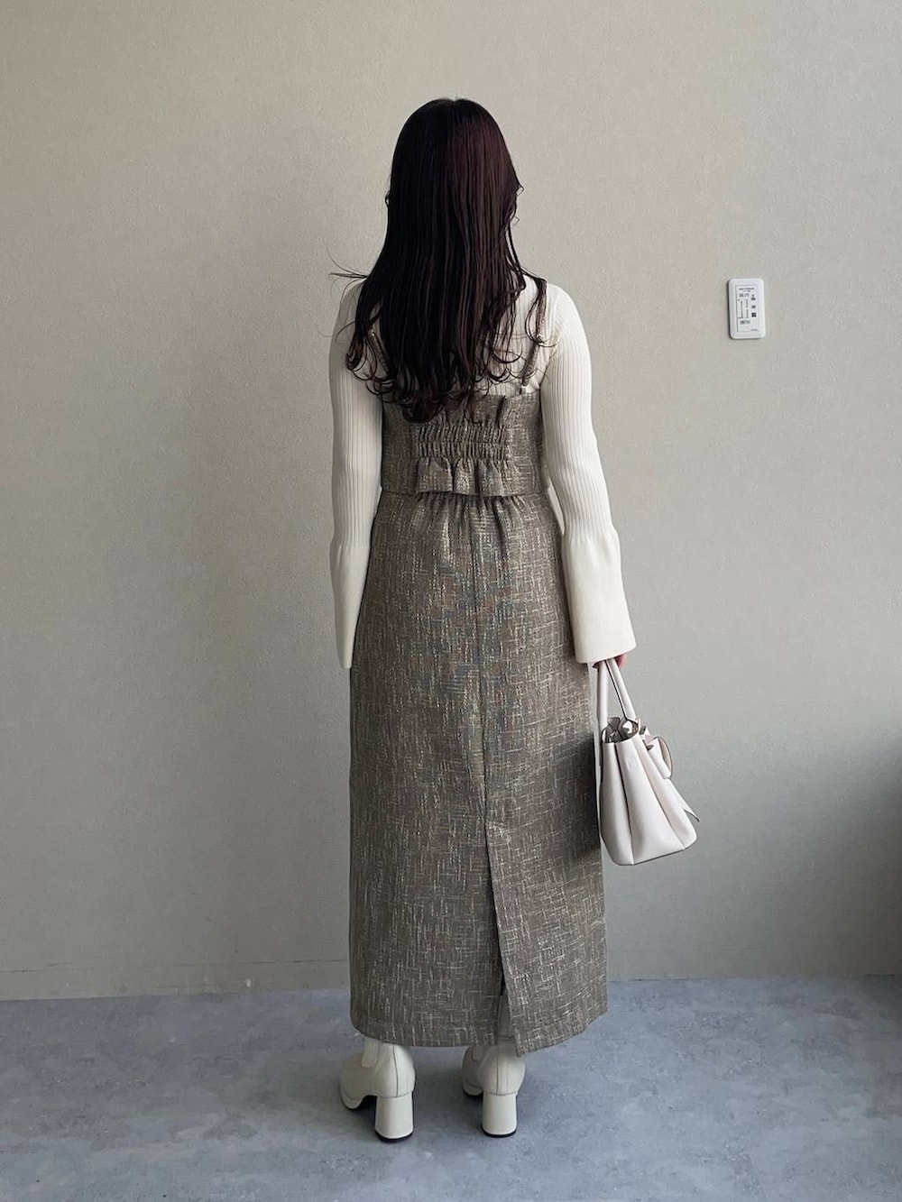 ホワイト系のピーコート、ホワイト系のブーツ、ホワイト系のニット/セーターを着用したレディースの秋コーディネートの4枚目の写真