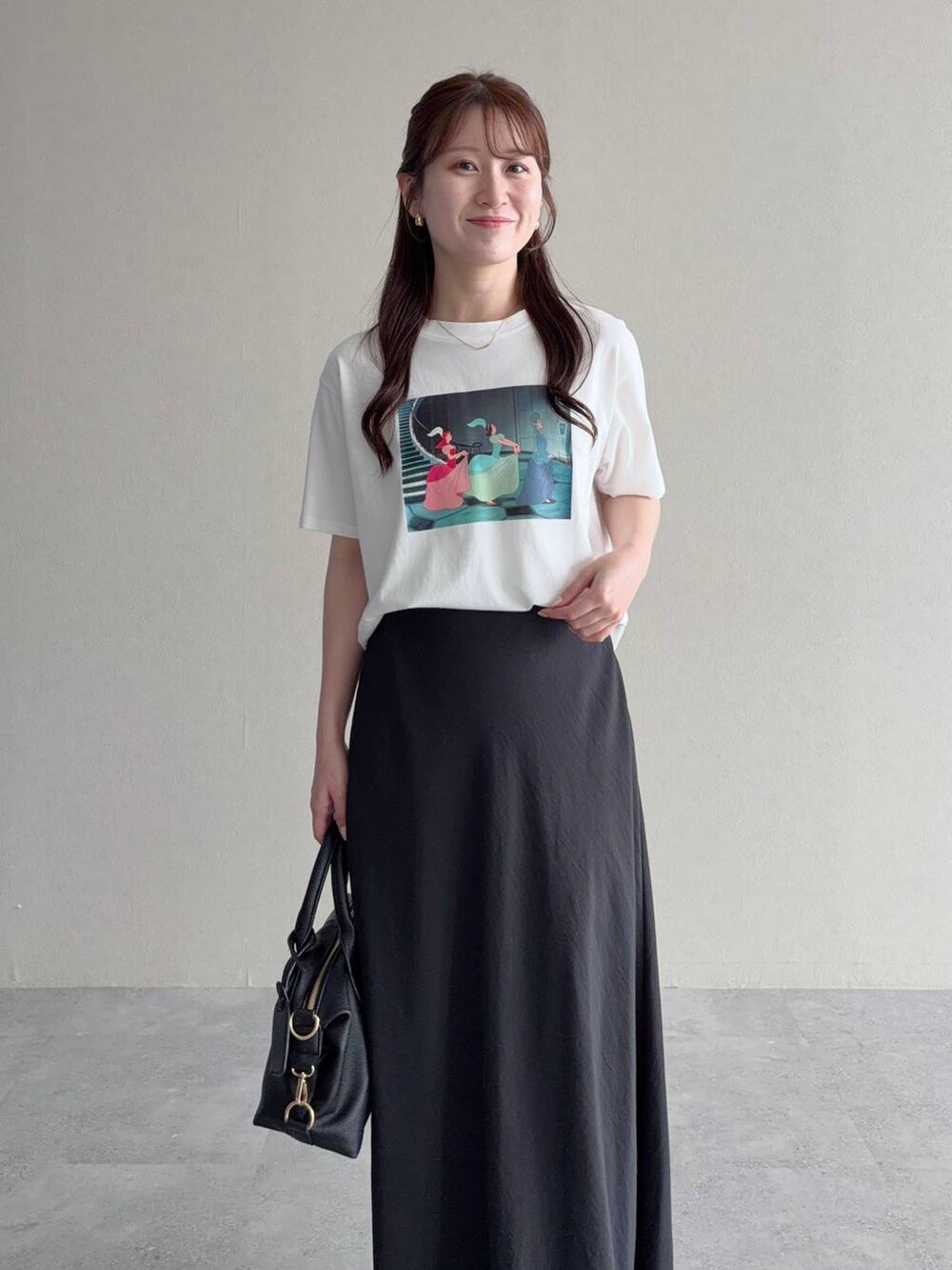ブラック系のボストンバッグ、ブラック系のスカート、ホワイト系のTシャツ/カットソーを着用したレディースの夏コーディネートの3枚目の写真