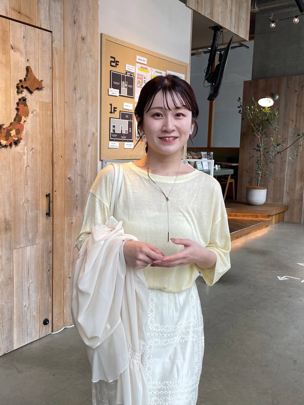 ベージュ系のパンプス、イエロー系のTシャツ/カットソー、ホワイト系のスカートを着用したレディースの春コーディネートの3枚目の写真