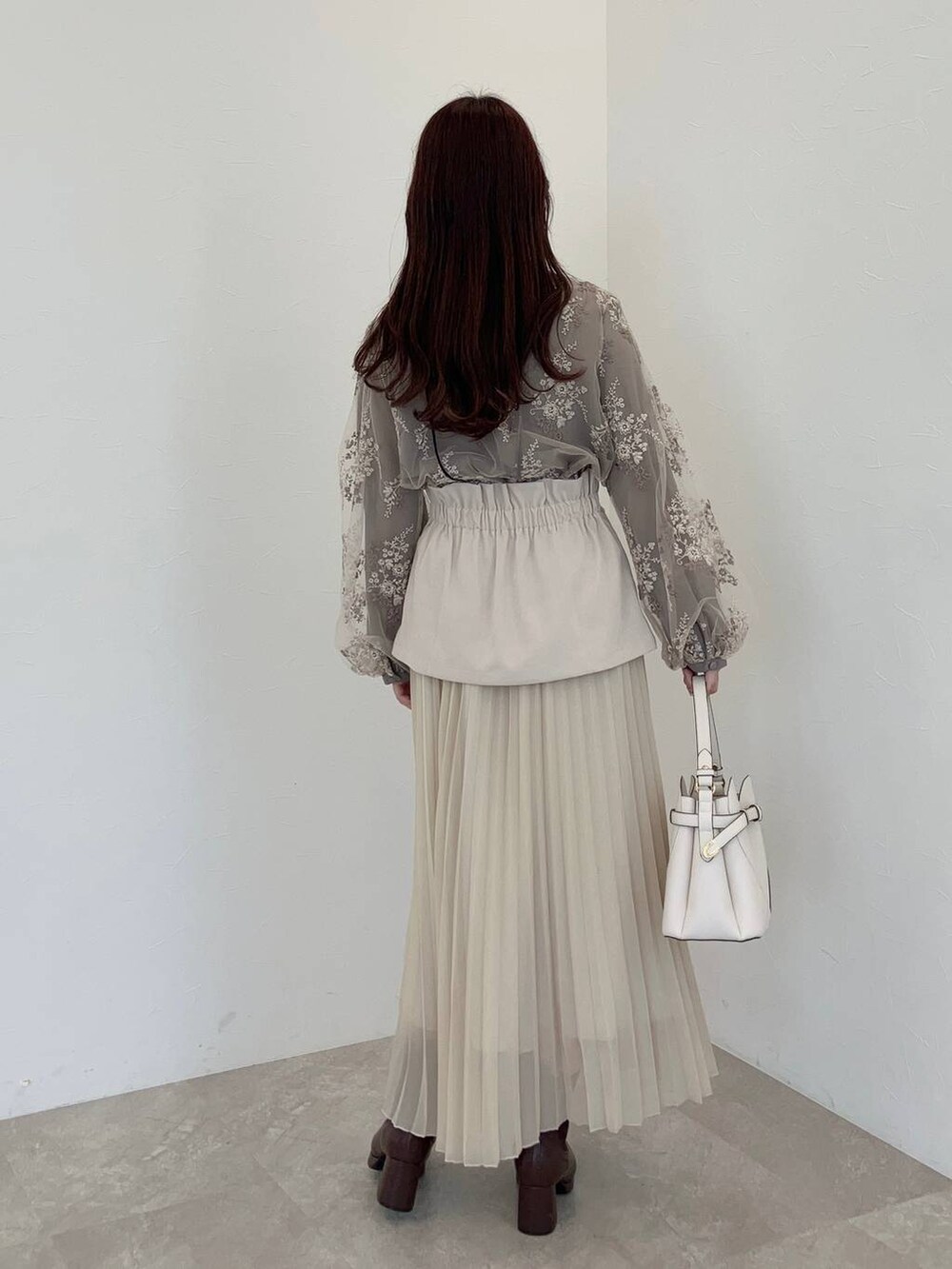 ホワイト系のショルダーバッグ、ブラウン系のシャツ/ブラウス、ブラウン系のブーツを着用したレディースの冬コーディネートの2枚目の写真