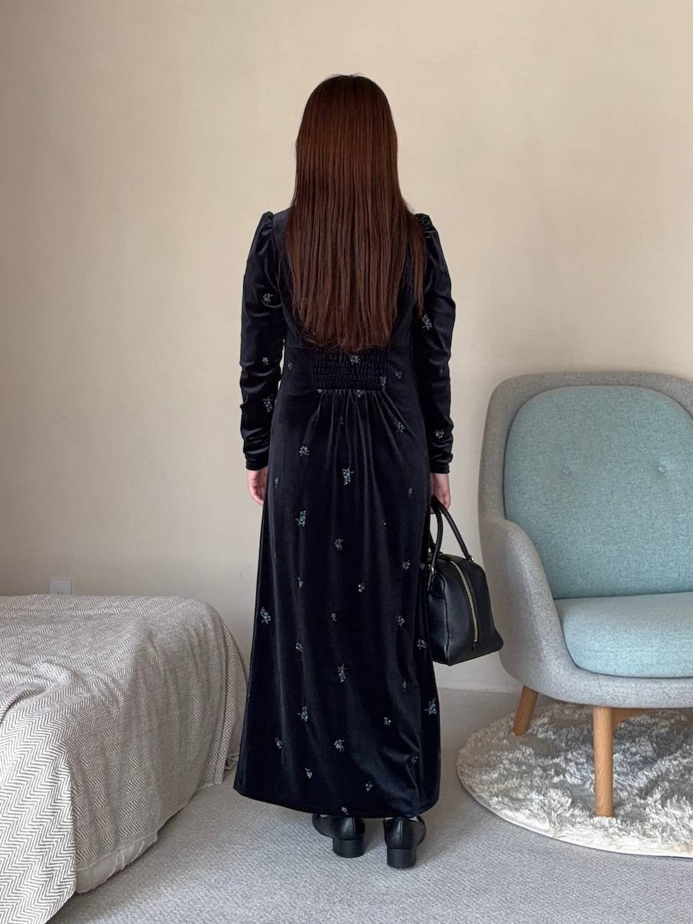 グレー系のワンピース、ブラック系のハンドバッグを着用したレディースの秋コーディネートの2枚目の写真
