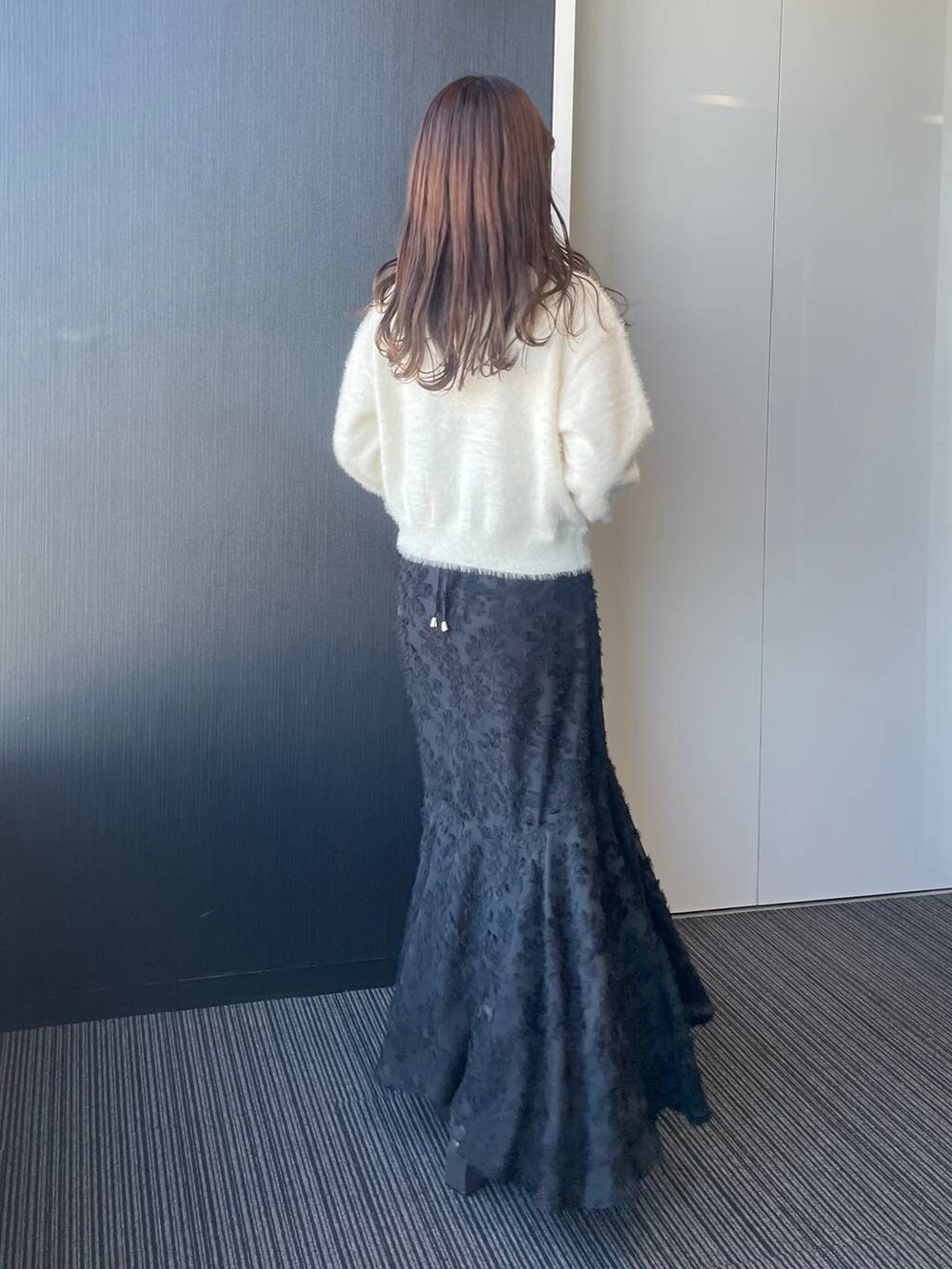 ホワイト系のニット/セーター、グレー系のブーツ、ブラック系のワンピースを着用したレディースの冬コーディネートの2枚目の写真