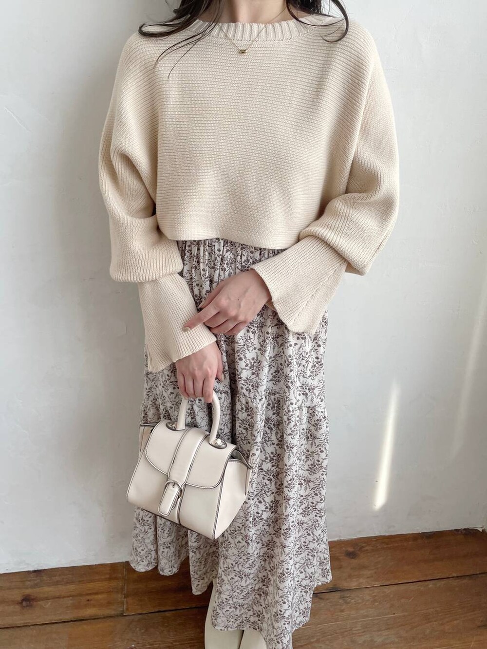 ホワイト系のハンドバッグ、ホワイト系のブーツ、ホワイト系のワンピースを着用したレディースの秋コーディネートの3枚目の写真