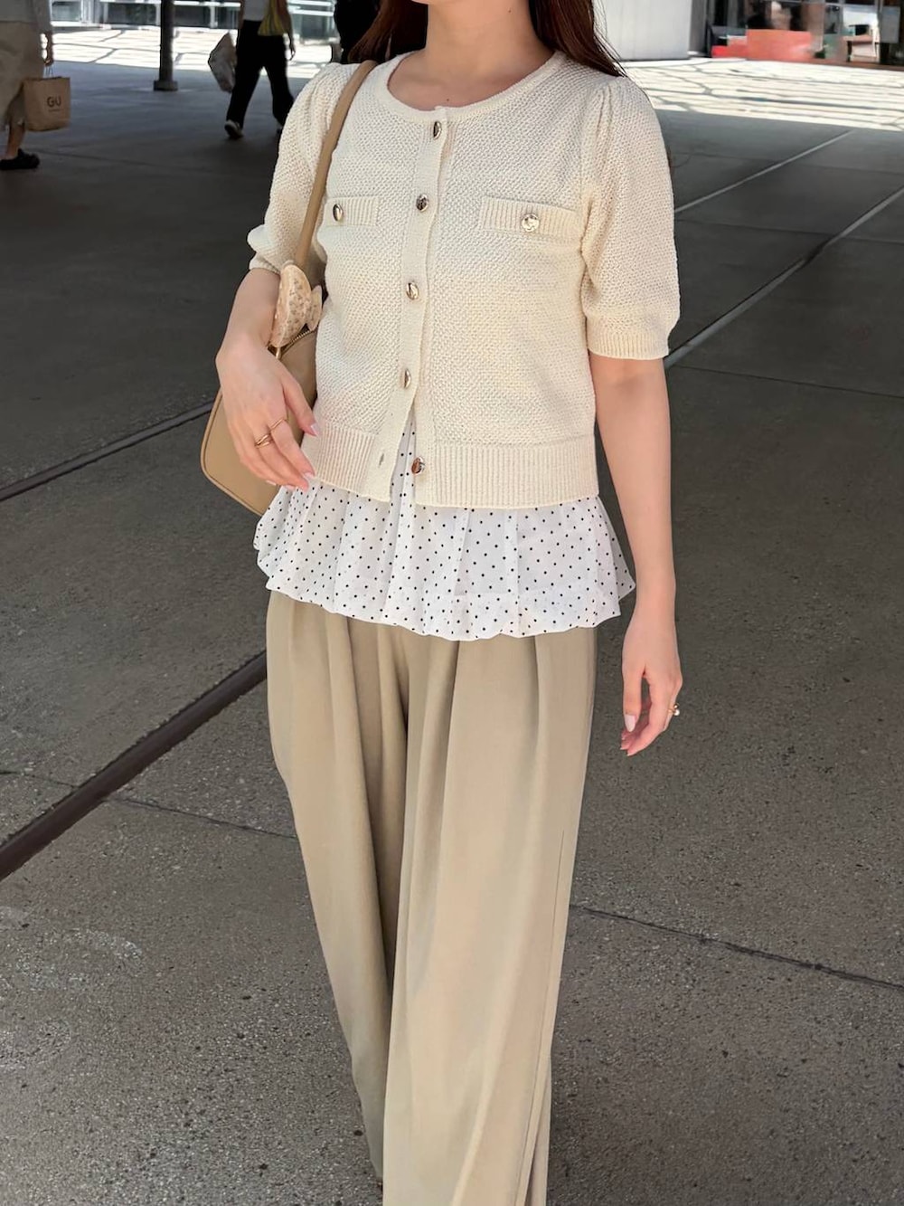 ホワイト系のカーディガン/ボレロ、ブラウン系のサンダル、ホワイト系のキャミソールを着用したレディースの夏コーディネートの3枚目の写真