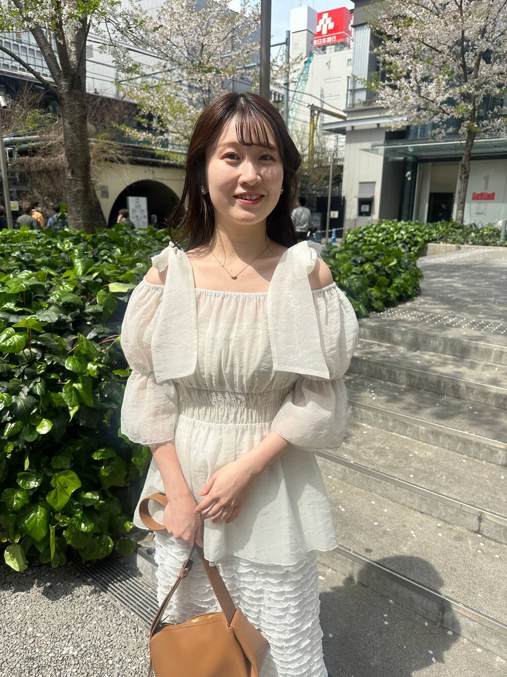 ベージュ系のサンダル、ホワイト系のスカート、ブラウン系のショルダーバッグを着用したレディースの春コーディネートの5枚目の写真