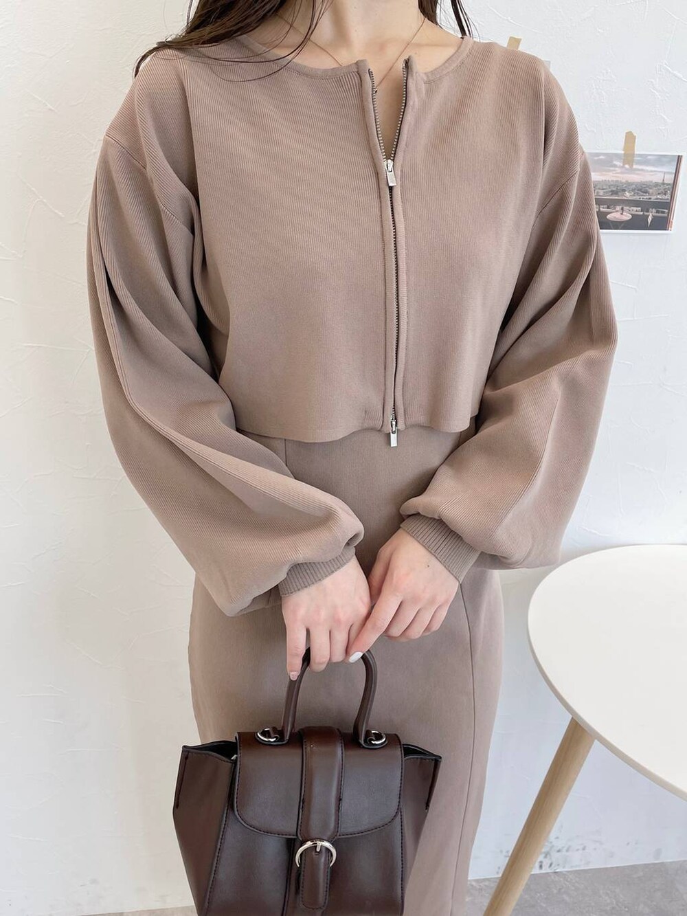 ブラウン系のハンドバッグ、ホワイト系のブーツ、ブラウン系のワンピースを着用したレディースの冬コーディネートの4枚目の写真