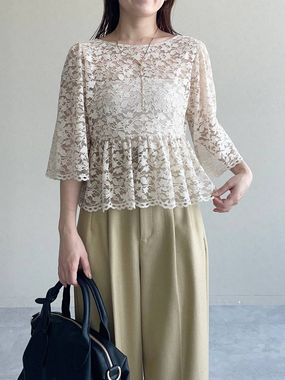 ブラック系のパンプス、ブラック系のボストンバッグ、ベージュ系のシャツ/ブラウスを着用したレディースの夏コーディネートの3枚目の写真