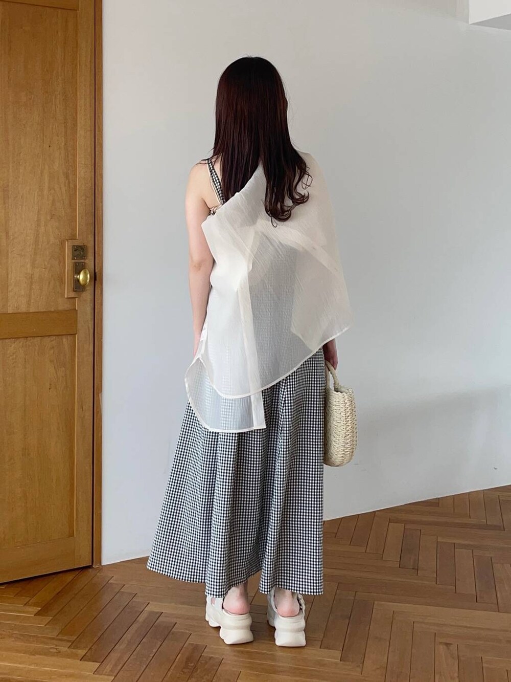 ベージュ系のシャツ/ブラウス、ホワイト系のサンダル、ベージュ系のかごバッグを着用したレディースの夏コーディネートの2枚目の写真