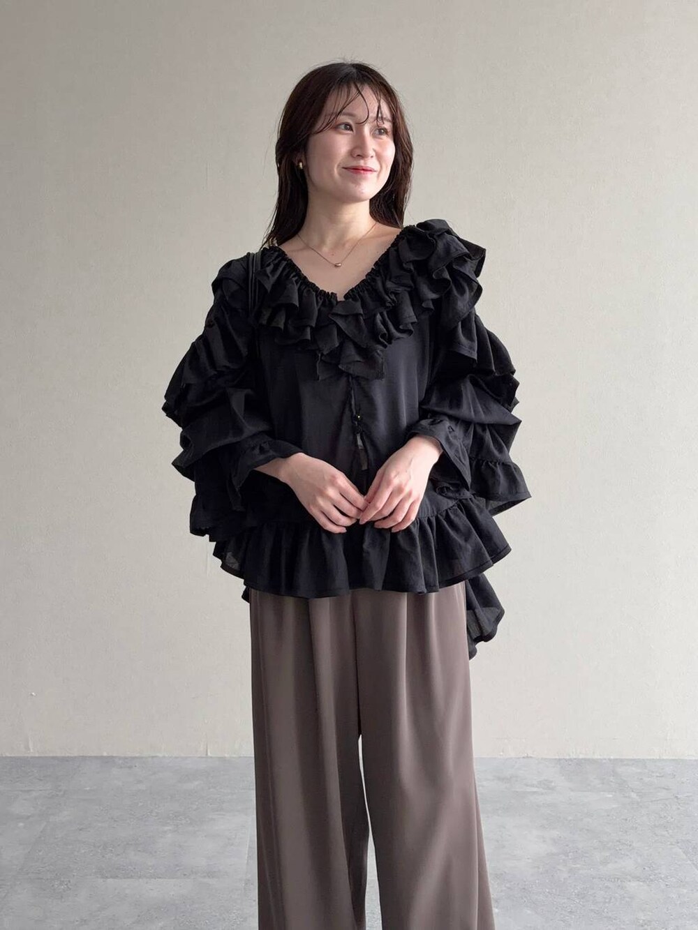 ブラック系のサンダル、ブラック系のシャツ/ブラウス、ベージュ系のパンツドレスを着用したレディースの春コーディネートの3枚目の写真