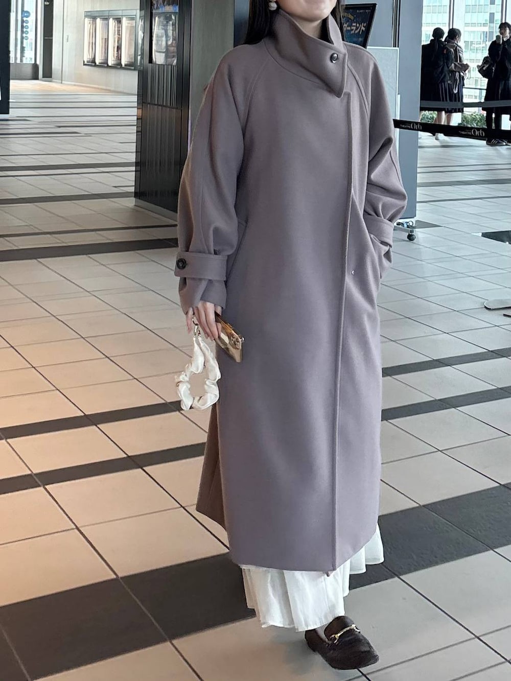 ブラウン系のチェスターコートを着用したレディースの冬コーディネートの4枚目の写真