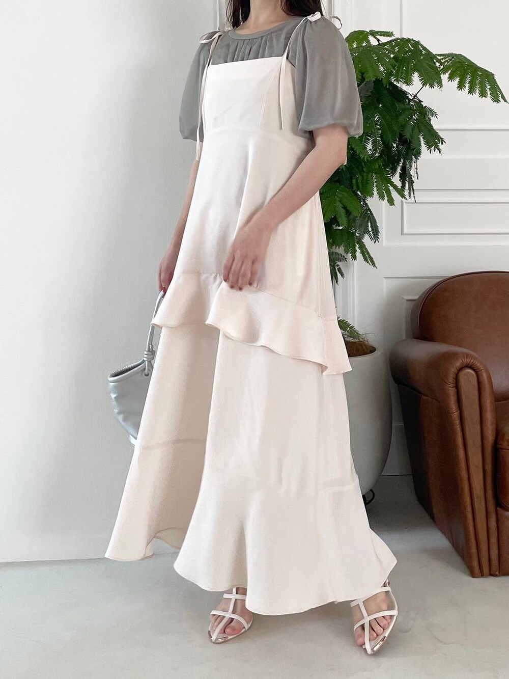 シルバー系のハンドバッグ、ホワイト系のサンダル、ホワイト系のワンピースを着用したレディースの夏コーディネートの4枚目の写真