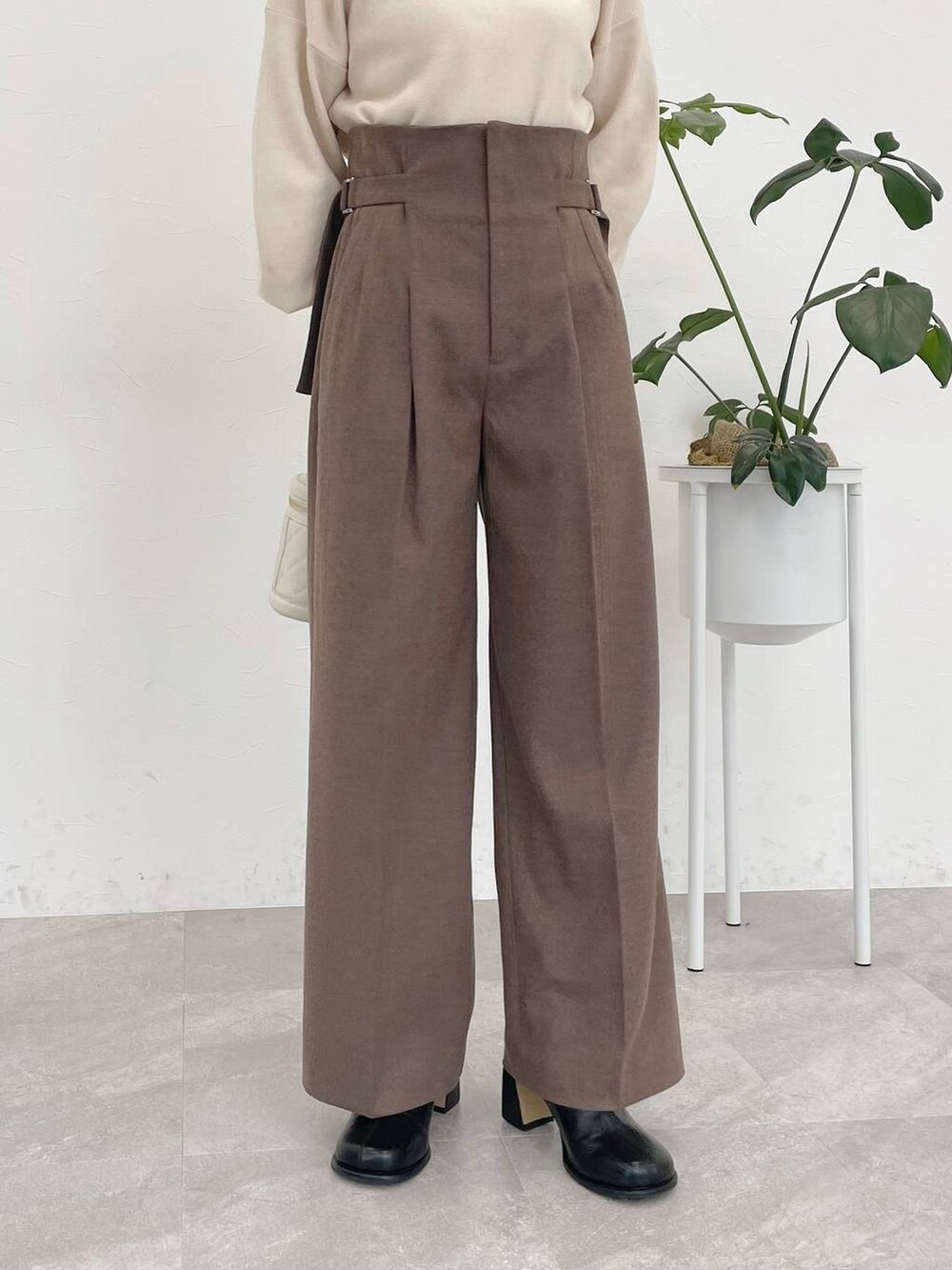 ベージュ系のその他パンツ、ブラック系のブーツ、ホワイト系のニット/セーターを着用したレディースの冬コーディネートの3枚目の写真