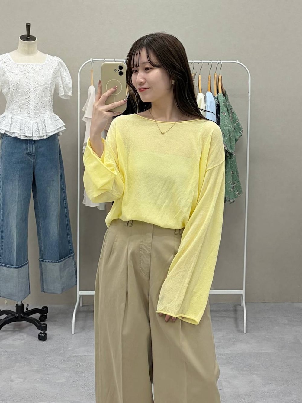 イエロー系のニット/セーター、ブラウン系のサンダル、ベージュ系のチノパンツを着用したレディースの春コーディネートの2枚目の写真