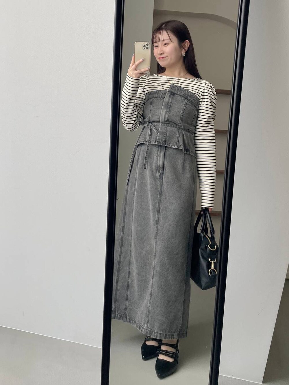 ホワイト系のTシャツ/カットソー、グレー系のスカート、ブラック系のパンプスを着用したレディースの春コーディネートの3枚目の写真