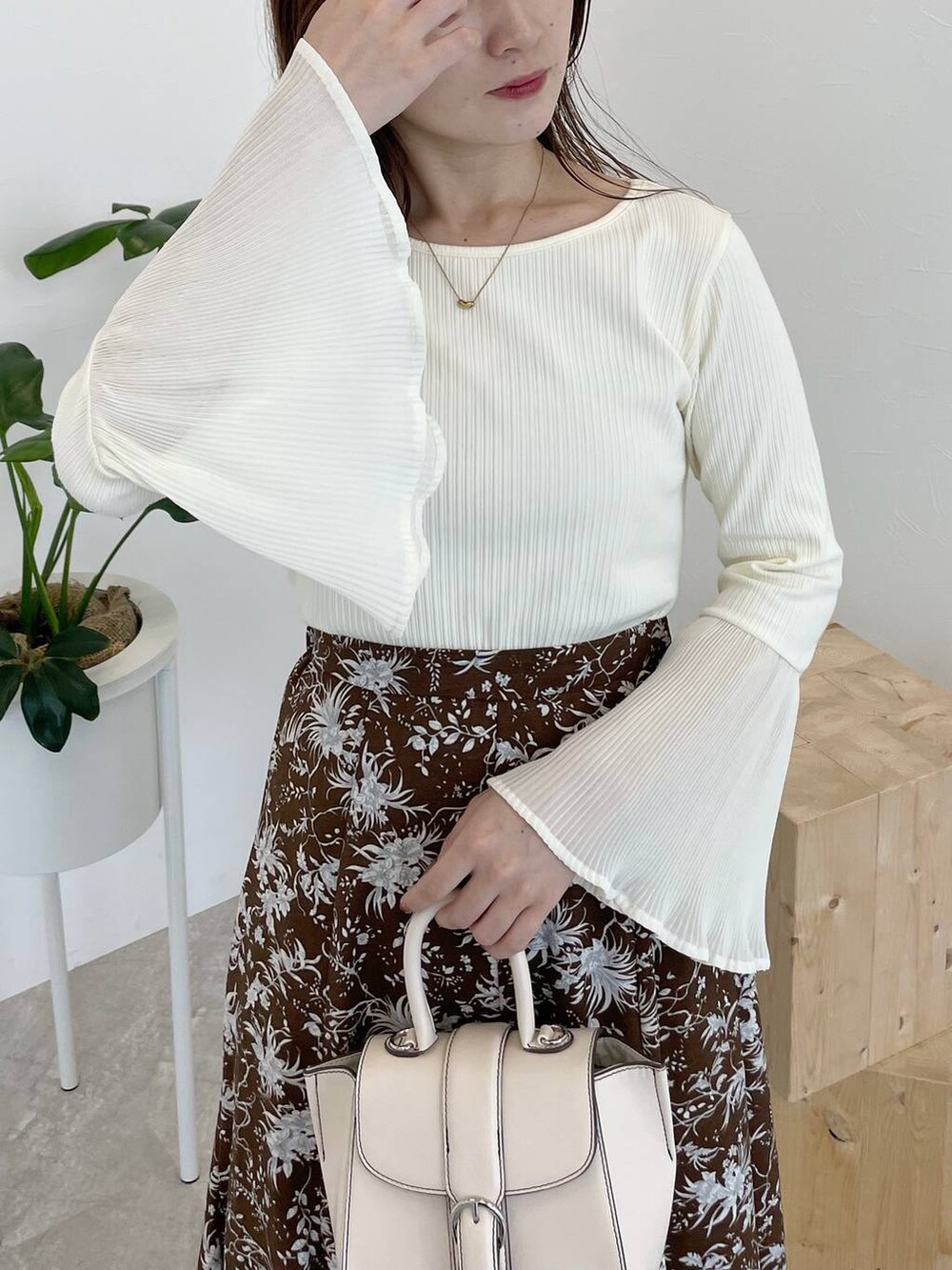 ブラウン系のスカート、ホワイト系のTシャツ/カットソー、ホワイト系のハンドバッグを着用したレディースの夏コーディネートの3枚目の写真