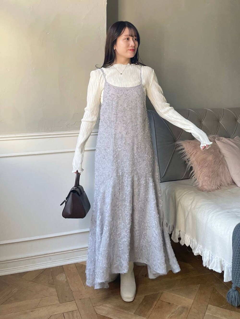 ブラウン系のハンドバッグ、ホワイト系のブーツ、ホワイト系のTシャツ/カットソーを着用したレディースの秋コーディネートの4枚目の写真