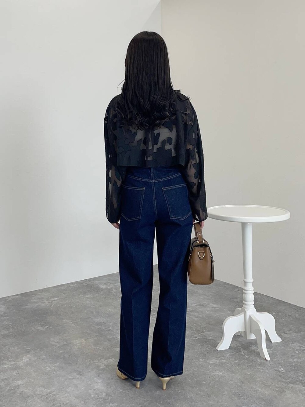 ブラック系のワンピース、ゴールド系のパンプス、ブラウン系のショルダーバッグを着用したレディースの秋コーディネートの2枚目の写真