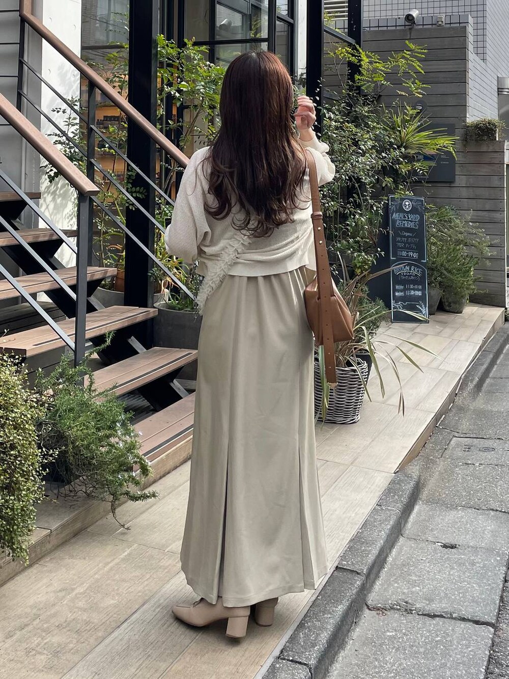 ブラウン系のショルダーバッグ、ホワイト系のカーディガン/ボレロ、ベージュ系のワンピースを着用したレディースの夏コーディネートの2枚目の写真