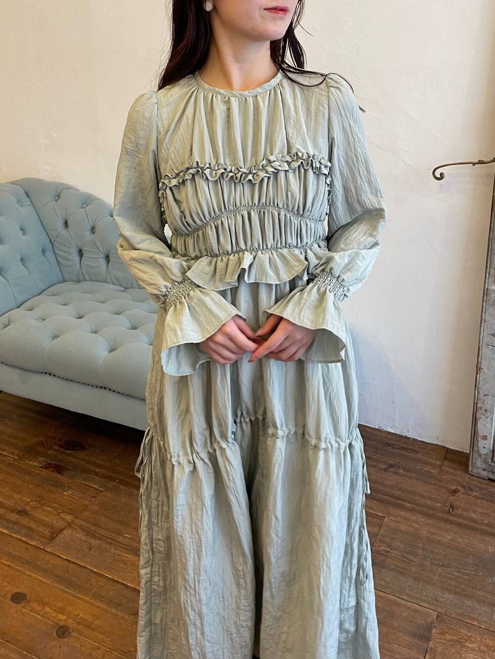 ブラウン系のブーツ、グリーン系のドレス、ホワイト系のショルダーバッグを着用したレディースの冬コーディネートの3枚目の写真