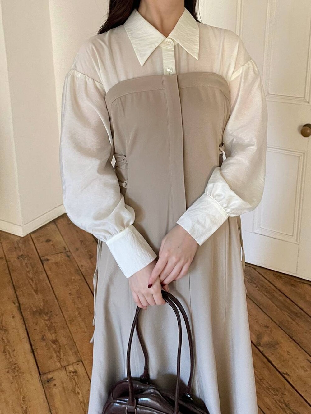 ブラウン系のブーツ、ブラウン系のハンドバッグ、ベージュ系のワンピースを着用したレディースの冬コーディネートの3枚目の写真