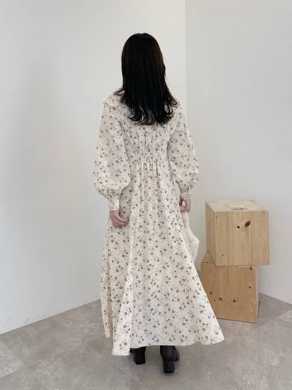 ブラウン系のカーディガン/ボレロ、ホワイト系のハンドバッグ、ブラウン系のブーツを着用したレディースの秋コーディネートの5枚目の写真