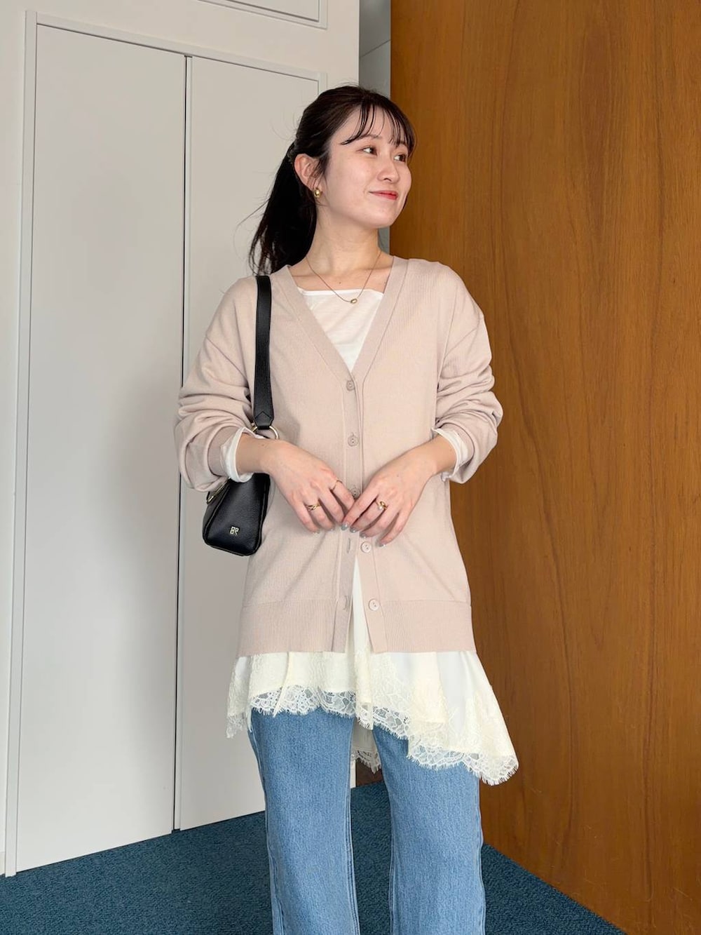 ブルー系のデニムパンツ、グレー系のカーディガン/ボレロ、ホワイト系のキャミソールを着用したレディースの春コーディネートの3枚目の写真